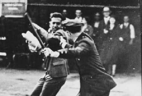 A confrontation between a policeman wielding a nightstick and a striker during the San Francisco General Strike, 1934.