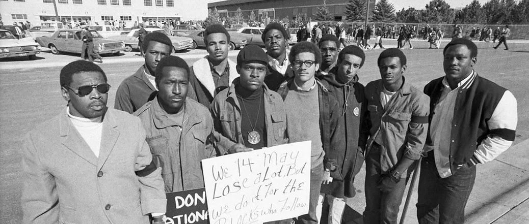 Members of the Black 14 holding a sign during their protest