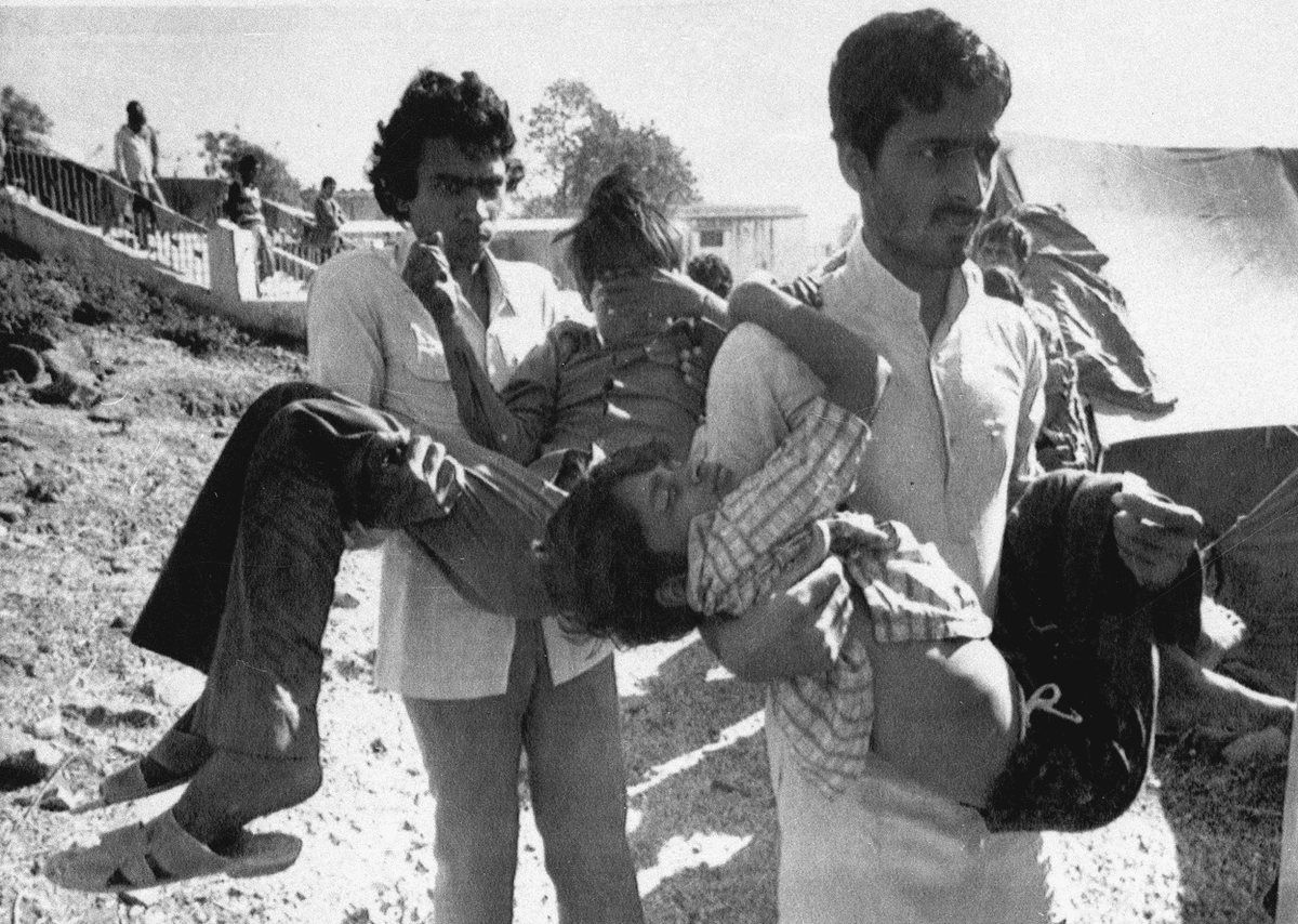 Two men carry children blinded by the Union Carbide chemical pesticide leak to a hospital in Bhopal, India, Dec. 5, 1984.