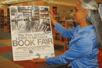Vaunda Nelson shows off a poster from 1976 that advertised a book fair honoring her great uncle, Lewis Michaux. (c) Gary Herron 