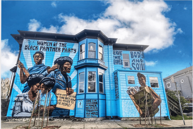 A colorful mural depicting the women of the Black Panther Party, painted on the side of a house in West Oakland.
