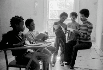 A photograph of Black Panther children in a classroom with their teacher, Evon Carter, widow of Alprentice “Bunchy” Carter, at the Intercommunal Youth Institute, the Black Panther Party school.