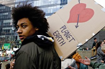 photo of young person at climate justice protest with sign
