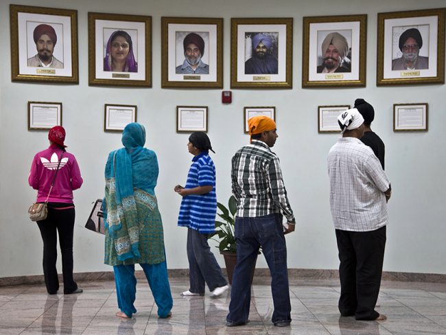 Visitors look at a memorial near the entrance of the Sikh Temple of Wisconsin Wednesday, July 31, 2013, in Oak Creek, Wisconsin