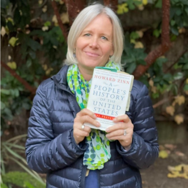 Woman holding Howard Zinn's A People's History of the United States book