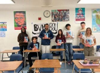 classroom holding up copies of book donated about African American veterans.