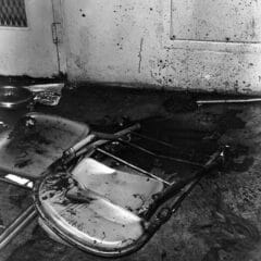 Raiford prison uprising aftermath, showing overturned chairs and blood on the wall.