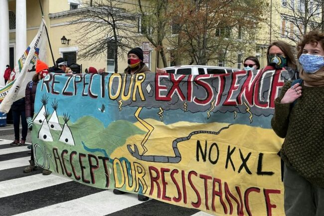 Activists display banners referring to shutting down existing oil pipelines in the northern United States at Black Lives Matter Plaza in Washington, DC. on April 1, 2021