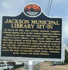 A historical marker in Jackson, Mississippi commemorating the Tougaloo Nine, students who were arrested for protesting segregation at the public library.