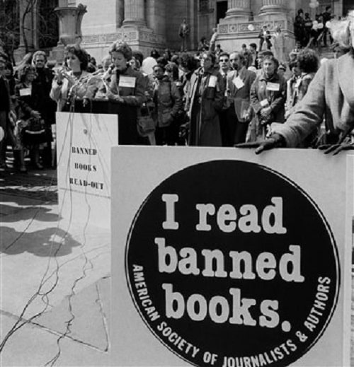 People protesting the banning of books at public schools and libraries, with one person holding a sign reading "I read banned books."